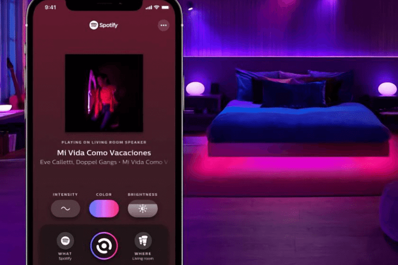 Man sieht die geöffnete Spotify App und bunte Philips Hue Lampen im Hintergrund.